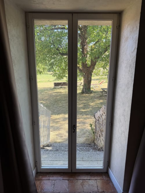 French cottage garden view through open French doors at Domaine les Bertrands, Couches