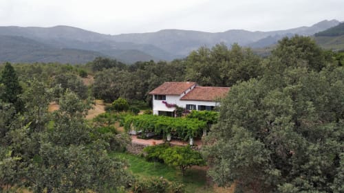 Casa rural blanca rodeada de olivares y montañas en Candeleda
