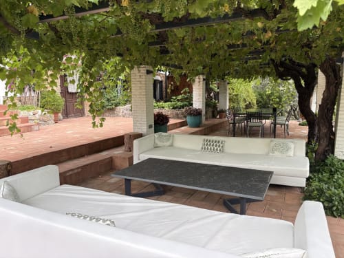 Rústica zona de descanso con sofás blancos bajo pérgola de viñas en El Escondite De Pedro Malillo, Candeleda