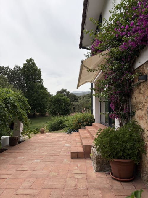 Terraza rústica de El Escondite De Pedro Malillo en Candeleda con buganvilia morada, tejas de barro y vistas al campo