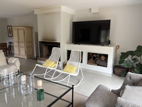 Elegante sala de estar en El Escondite De Pedro Malillo, Candeleda, con chimenea, televisión, asientos y plantas
