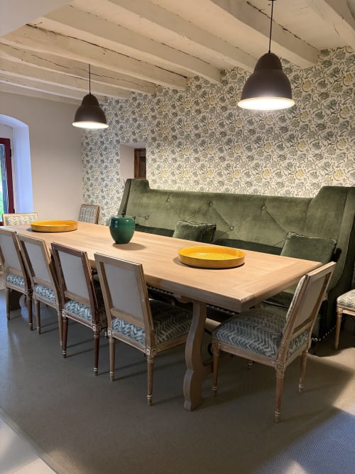 Comedor moderno en El Escondite De Pedro Malillo, Candeleda, con mesa de madera, sofá verde, sillas estampadas y lámparas colgantes