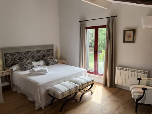 Habitación luminosa en El Escondite De Pedro Malillo en Candeleda con cama queen, puertas francesas rojas, pisos de madera y estilo moderno
