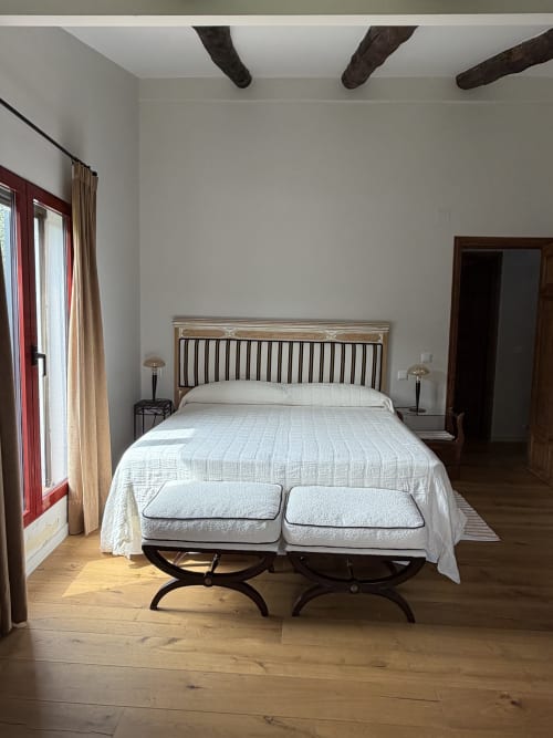 Amplio dormitorio en El Escondite De Pedro Malillo, Candeleda, con vigas de madera, ropa de cama blanca y encanto rústico
