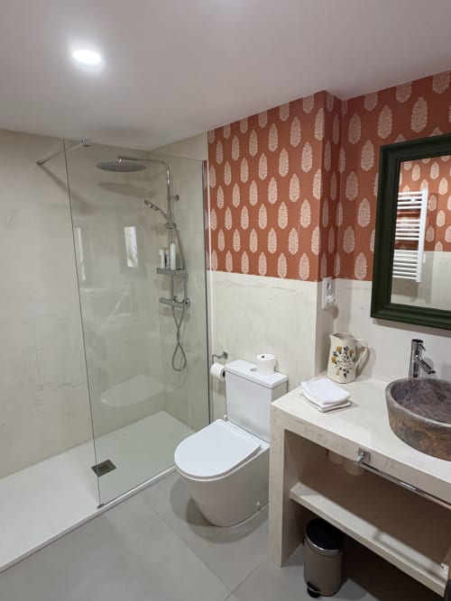 Baño moderno en El Escondite De Pedro Malillo de Candeleda con ducha a ras de suelo, inodoro blanco, lavabo tipo recipiente y acabados en terracota