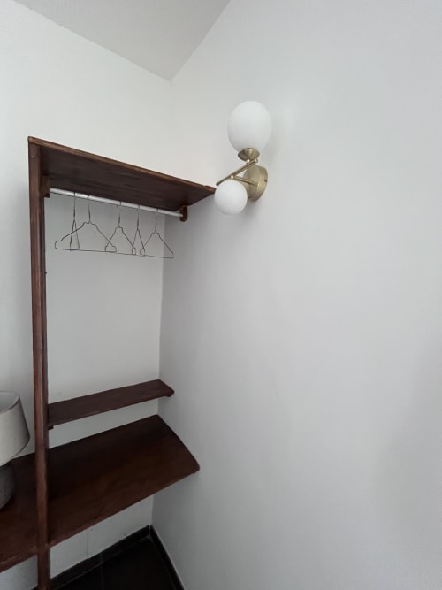Moderno armadio con struttura in legno e applique in ottone nella suite dell'hotel Cuore di Rocca, Rocca di Papa