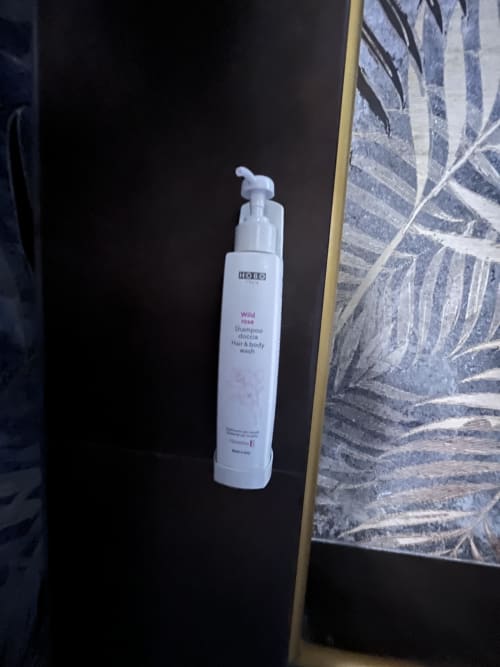 Flacone pompa bianco di shampoo Wild Rose e bagnoschiuma esposto presso l'hotel Cuore di Rocca a Rocca di Papa