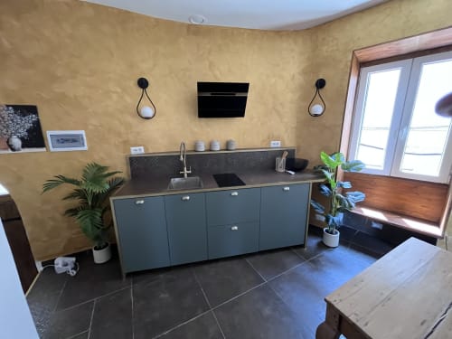 Cucina moderna dell'appartamento Piazza Vecchia a Cuore di Rocca, Rocca di Papa, con mobili scuri, lavello e pareti gialle