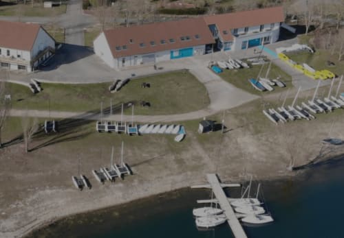 Aerial view of Le Paradis de Lucile waterfront B&B in La Roche Guyon with boathouses, docks, and riverside grounds near