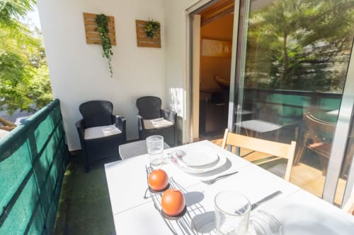Terraza soleada del apartamento Marina Galé en Portimão con mesa de comedor, tumbonas y vistas al jardín