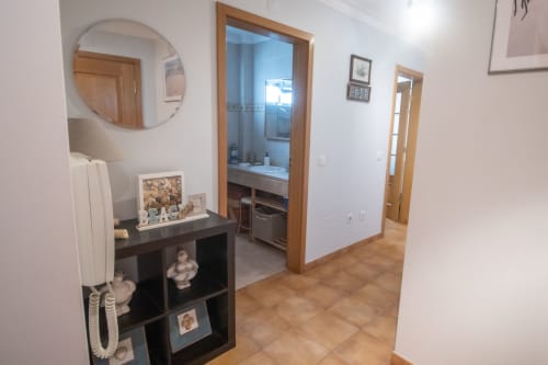 Pasillo moderno del apartamento en Marina Galé de Portimão con acceso a baño y dormitorio, decorado con espejos y muebles