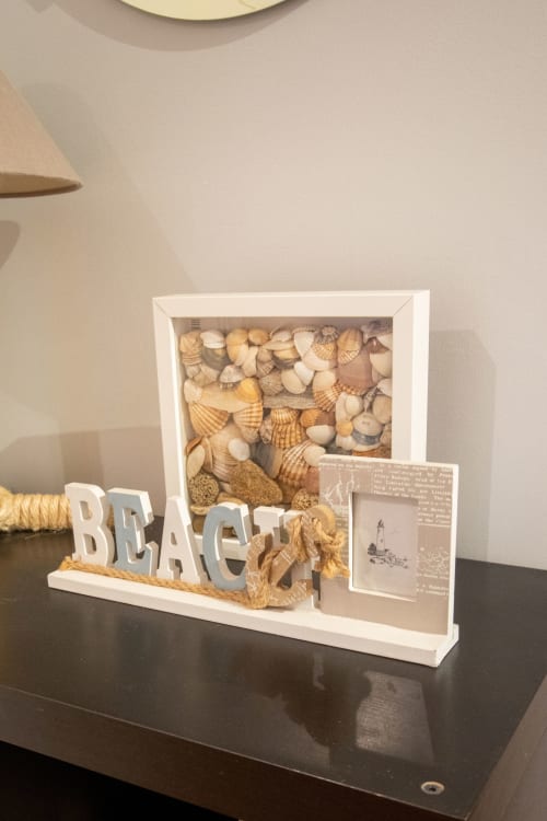 Decoración temática de playa con conchas marinas y cartel 'BEACH' en apartamento Urban Beach Rentals Portimão