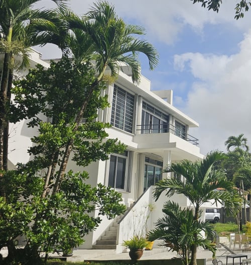 Moderne weiße Villa in der Habitation Villa Les Cassias in Petit-Bourg, Guadeloupe mit tropischer Palmenbepflanzung