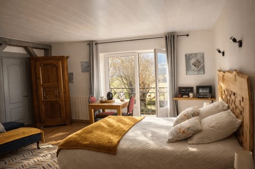 Chambre lumineuse à l'Auberge La Source Bleue, Cusance, avec mobilier en bois, balcon avec vue sur le jardin et équipements modernes
