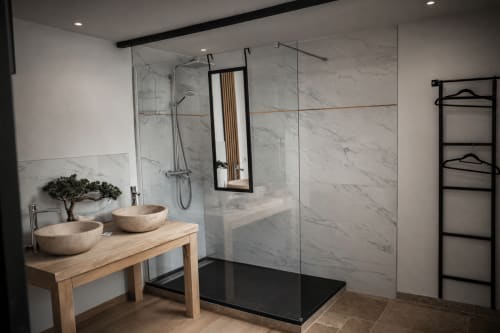Salle de bain moderne de la Suite Saint Ermenfroy à La Source Bleue, Cusance avec murs en marbre, meuble vasque en bois, vasques en pierre