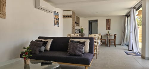 Espace de vie loft moderne à Mi Casa Es Su Casa avec canapé sombre, coin repas, kitchenette et vue sur le jardin depuis la terrasse
