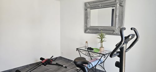 Salle de fitness moderne de l'appartement Le Loft à Mi Casa Es Su Casa, Villemoustaussou, avec vélo d'exercice, miroir et décoration