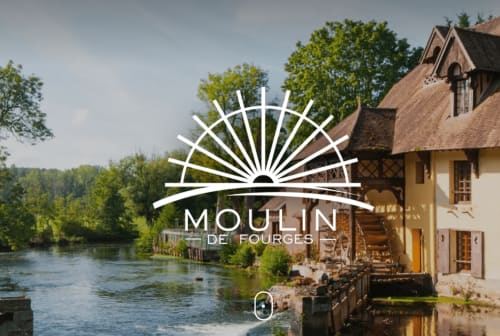 Historic Moulin de Fourges mill property on riverside in La Roche Guyon, France with traditional architecture