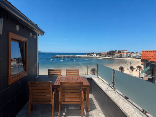 Balcón frente al mar del dúplex Holibai Nigrán con muebles de madera con vistas a Praia Loura y al océano
