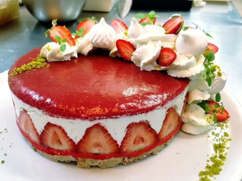 Élégant gâteau aux fraises avec glaçage rouge, crème fouettée et garnish de pistache au Domaine de la Gare M, Mortagne-sur-Gironde