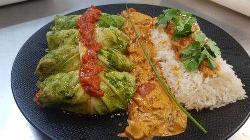 Assiette gastronomique avec poulet enrobé d'herbes, curry, sauce rouge et riz blanc au Domaine de la Gare M à Mortagne-sur-Gironde