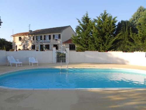 Piscine du Domaine de la Gare M avec transats et bâtiment à Mortagne-sur-Gironde