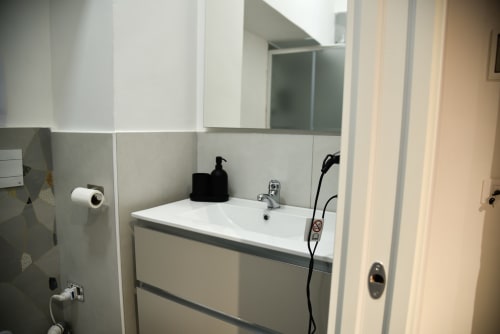 Bagno moderno con lavabo bianco, specchio e vanity nella camera doppia Onde Del Mare di Napoli