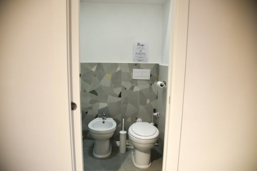 Bagno moderno dell'hotel Onde Del Mare a Napoli con bidet, wc, lavabo e piastrelle geometriche dal design costiero