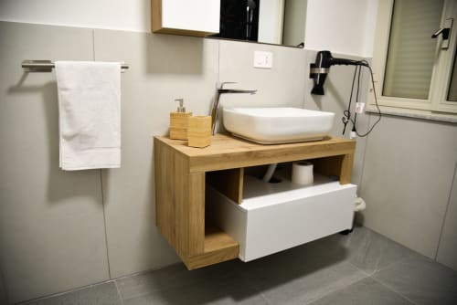 Vanità da bagno moderna con lavabo in ceramica bianca, mobile in legno e portasciugamani dell'hotel boutique Onde Del Mare a Napoli