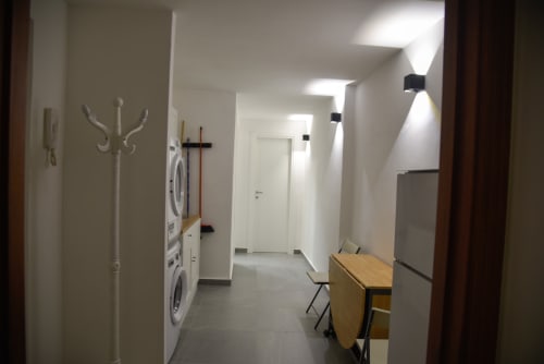 Corridoio dell'appartamento Onde Del Mare a Napoli con lavatrici, attaccapanni e moderni apparecchi di illuminazione
