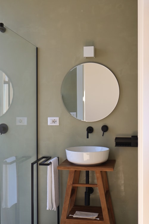 Bagno moderno della Quercia con specchio rotondo, lavabo bianco su supporto in legno e doccia walk-in