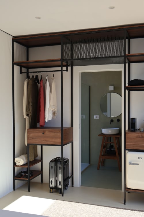 Guardaroba moderno con appendiabiti, scaffalature in legno e valigie presso la Quercia Private Nature Retreat a Maglie