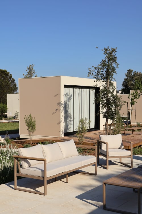 Area lounge esterna moderna presso Quercia Private Nature Retreat con mobili in legno e padiglione contemporaneo a Maglie, Italia