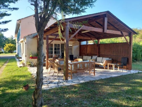 Wooden pergola patio with furniture at Domaine de la Gare M, a B&B in Mortagne-sur-Gironde, France