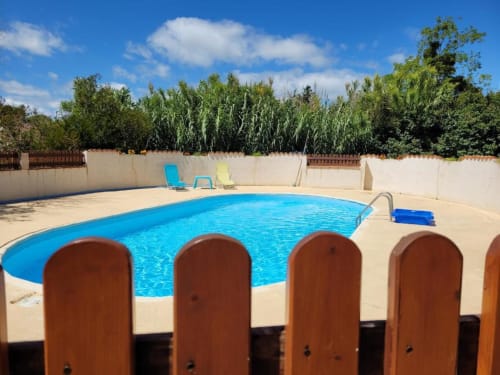 Swimming pool at Domaine de la Gare M in Mortagne-sur-Gironde with lounge chairs and rural backdrop