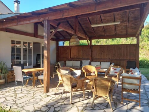 Covered patio with rattan chairs and wooden beams at Domaine de la Gare M, Mortagne-sur-Gironde
