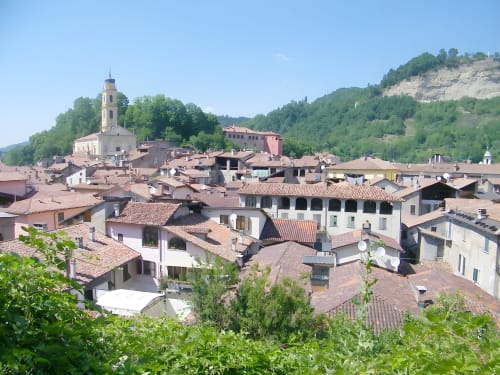 Storico borgo collinare di Ceva con tetti in cotto, campanile e montagne verdeggianti intorno alla Residenza Basiglio B&B