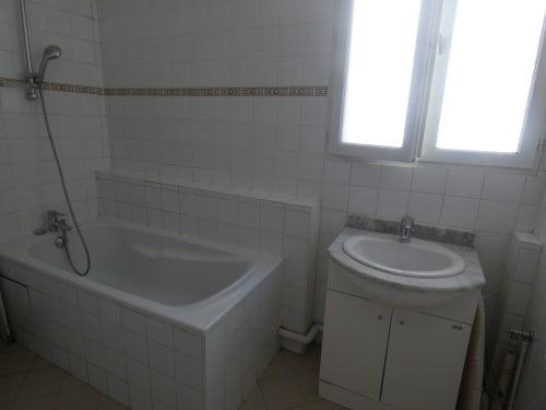 Salle de bain de la villa Sci Ludji à Nanterre avec baignoire, lavabo et carrelage décoratif