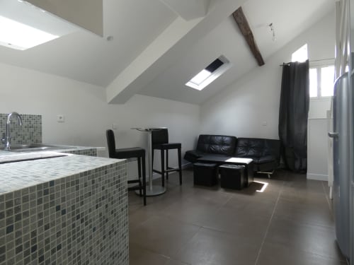 Studio moderne à Nanterre avec cuisine ouverte, salle à manger et sièges en cuir noir