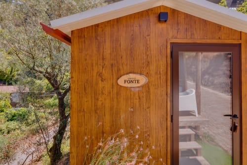 Wooden cabin entrance at Arrabia Guest Houses Glamping in Castelo de Paiva, Portugal with Cabana da Fonte sign