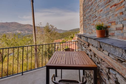 Varanda da Casa Bernardo em Raiva com mesa, vistas de montanha, parede de tijolos e terraço com vista para vale arborizado