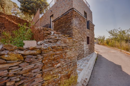 Fachada de pedra da Casa Bernardo nas Casas de Hóspedes Arrabia em Castelo de Paiva, Portugal, com arquitetura moderna e pavimentação