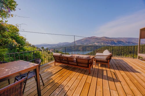 Terraço de madeira com assentos com vista para o rio nas Glamping Arrabia Guest Houses em Castelo de Paiva, Portugal