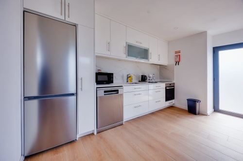 Cozinha moderna da Casa Costa em Arrabia Guest Houses com eletrodomésticos em aço inoxidável e armários brancos