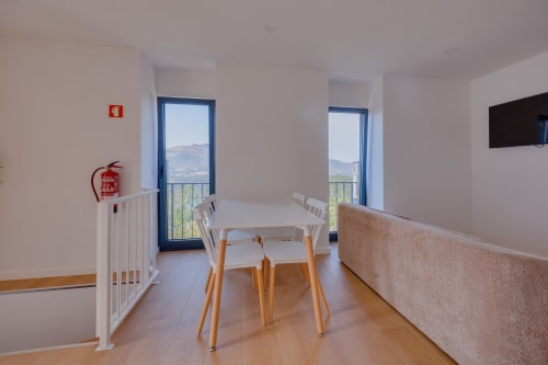 Sala de refeições moderna da Casa Costa em Arrabia Guest Houses com vista para as montanhas através de portas com moldura azul