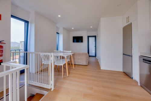 Área de estar moderna em plano aberto na Arrabia Guest Houses com mesa de jantar, cadeiras brancas e vista para o rio em Casa Costa, Castelo
