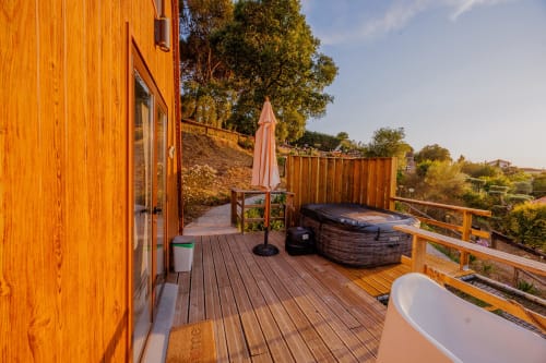 Terraço em madeira com banheira de hidromassagem, guarda-sol e vistas do vale na Arrabia Guest Houses Glamping, Castelo de Paiva Portugal