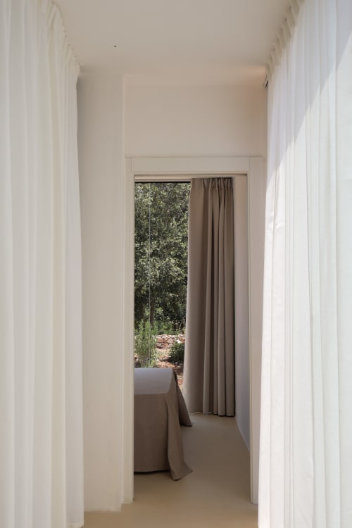 Corridoio minimalista della Quercia Private Nature Retreat con tende bianche trasparenti che incorniciano la vista del paesaggio forestale