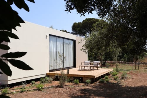 Elegante suite glamping bianca con terrazza in legno presso Quercia Private Nature Retreat a Maglie, Italia, circondata da alberi