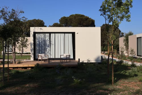 Moderno bungalow bianco con terrazza in legno presso Quercia Private Nature Retreat a Maglie, Italia, con architettura minimalista